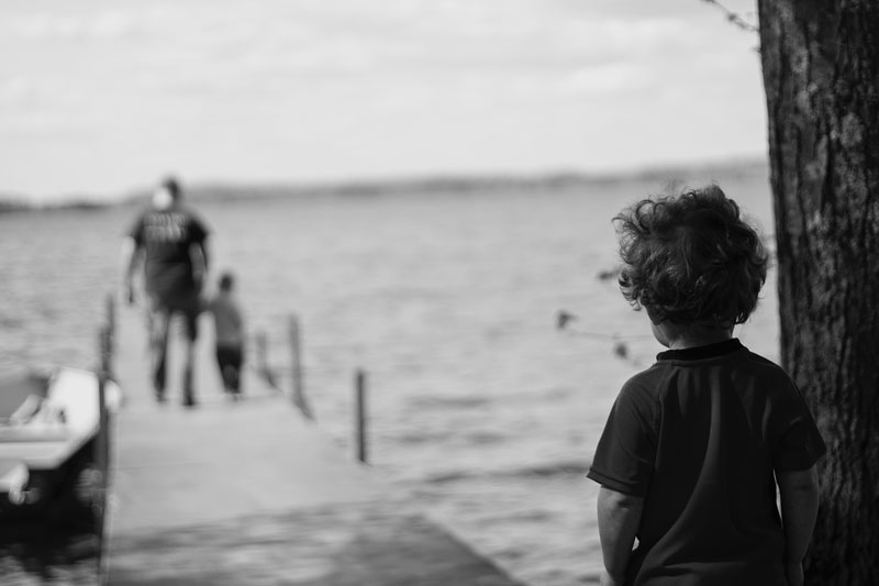 αγοράκι που κοιτάει μια οικογένεια σε μια προβλήτα