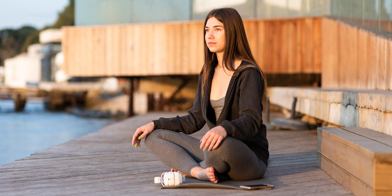 γυναίκα εφαρμόζει Mindfulness στην παραλία