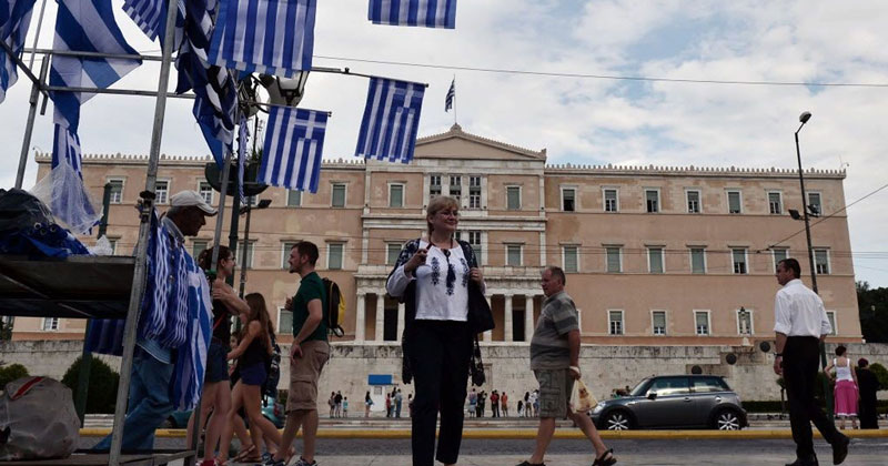 άντρας κάθεται σε καναπέ και πιάνει το κεφάλι του αγχωμένος