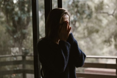 λυπημένη γυναίκα σκέφτεται πώς να αναγνωρίσει και να αντιμετωπίσει το Gaslighting