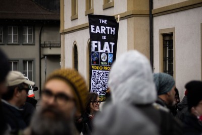 άτομο σε κοινό υποστηρίζει τη θεωρία συνομωσίας ότι η γη είναι επίπεδη