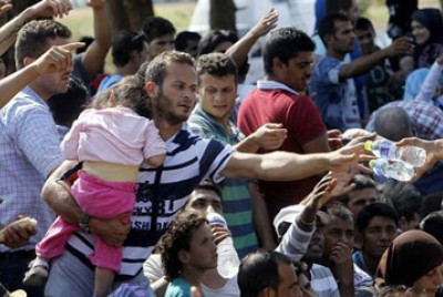 πρόσφυγες προσπαθούν να πάρουν νερά και φαγητό
