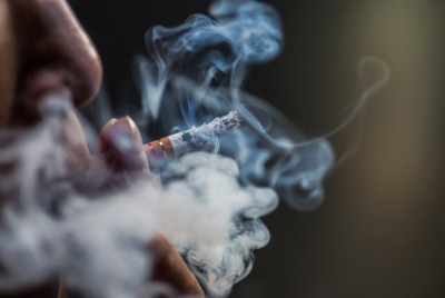 χέρι κρατάει ένα τσιγάρο που καίει ακολουθώντας συγκεκριμένα μοτίβα εθισμού