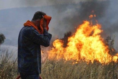 άνδρας που προστατεύει το πρόσωπό του με φωτιά να καίει πίσω του