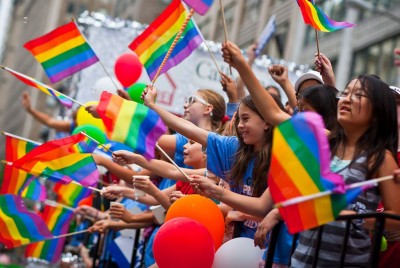 κόσμος που κρατάει σημαίες του lgbt pride