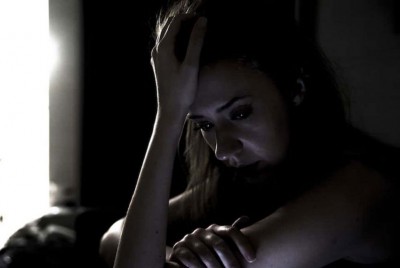 γυναίκα στο δωμάτιό της λυπημένη κρατάει το κεφάλι της