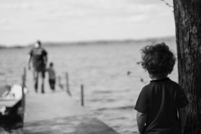 αγοράκι που κοιτάει μια οικογένεια σε μια προβλήτα