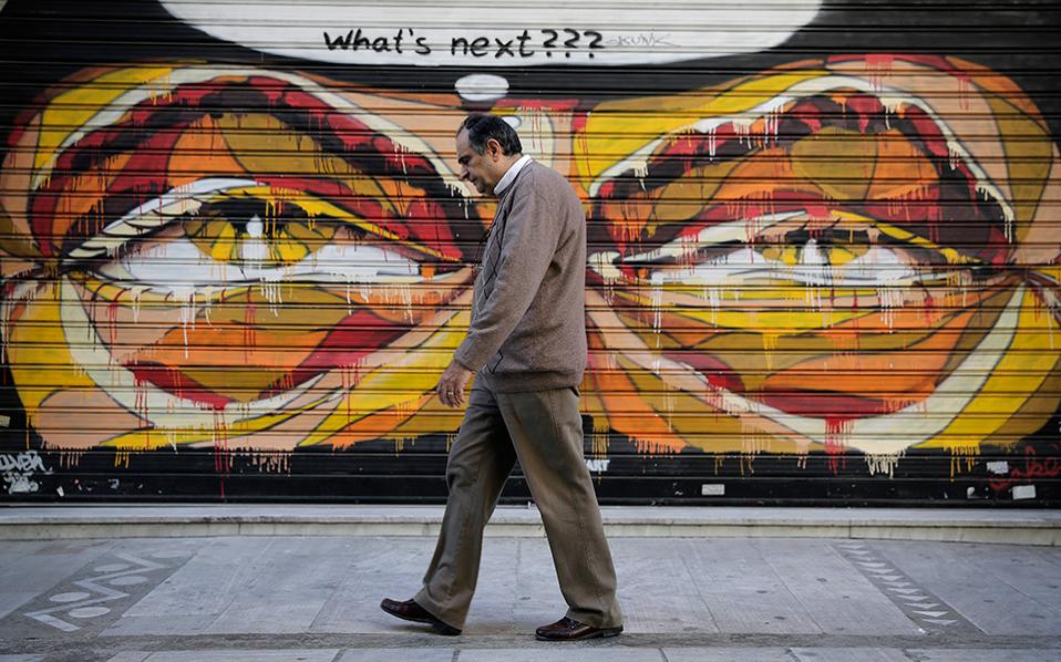 άντρας μεσήλικος περπατάει στην πόλη μπροστά από ένα γκράφιτι