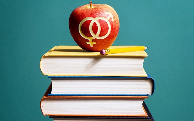 μήλο με χαραγμένα τα σύμβολα των φύλων πάνω σε βιβλία